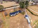 Expansive aerial view showcasing the home's layout, surrounding land, outbuildings, and outdoor amenities at 4739 Lower Jersey Rd, Oxford, GA 30054