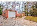 Single-Gathering home featuring an attached garage, driveway, and a well-maintained lawn at 1410 Willow Dr, Riverdale, GA 30296
