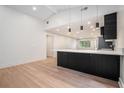 A modern kitchen is shown with black cabinets, stainless steel appliances, and hardwood floors at 3052 Brook Dr, Decatur, GA 30033