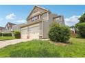 Two-story home with vinyl siding, a two-car garage, and well-maintained landscaping at 7099 Skippingstone Way, Douglasville, GA 30134