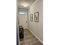 Bright entryway with wood-look flooring, artwork, and a console table at 776 Woodstock Grove Dr, Woodstock, GA 30188