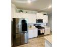 Bright, spacious kitchen featuring stainless steel appliances, granite countertops, and modern white cabinets at 776 Woodstock Grove Dr, Woodstock, GA 30188