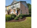 Brick townhome with manicured landscaping, lush green grass, and mature trees in a well-kept community at 803 Arbor Gate Ln, Lawrenceville, GA 30044