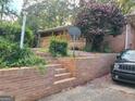 Exterior view of home featuring brick stairs, mature landscaping, and a black Jeep at 1723 Fort Valley Sw Dr, Atlanta, GA 30311