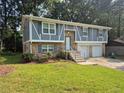 Attractive split-level home showcases fresh exterior paint, a well-manicured lawn, and a convenient two-car garage at 3975 Northstrand Dr, Decatur, GA 30035