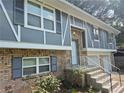 Charming brick home features updated siding, black shutters, and a welcoming entrance with a white railing at 3975 Northstrand Dr, Decatur, GA 30035