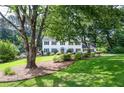 Charming two-story home showcasing a beautifully landscaped front yard with lush greenery and vibrant flowers at 4714 Marc Sw Ct, Lilburn, GA 30047