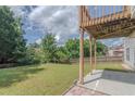 Lush backyard with a spacious lawn, mature trees, and a patio area, perfect for outdoor activities at 851 Roget Ct, Lawrenceville, GA 30045