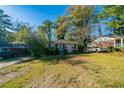Cozy single-story home with mature trees, a well-kept lawn, and a car in the driveway at 1555 Rupert Rd, Decatur, GA 30032