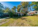 Cozy single-story home with mature trees, a well-kept lawn, and a car in the driveway at 1555 Rupert Rd, Decatur, GA 30032
