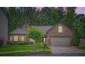 Charming brick home at dusk featuring a well-manicured lawn and a two-car garage at 1873 Jameson Cir, Lawrenceville, GA 30043