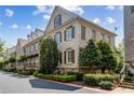 Brick townhome displaying multiple windows, mature trees, and professionally landscaped front yard at 2362 Saint Davids Nw Sq, Kennesaw, GA 30152