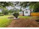Manicured front yard with vibrant green grass, garden with flowers, and a charming home with a cozy front porch at 2736 Joyce Ave, Decatur, GA 30032