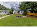 Landscaped front yard with vibrant green grass, garden with flowers, and a charming home with a cozy front porch at 2736 Joyce Ave, Decatur, GA 30032