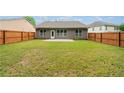 Spacious fenced backyard with a well-maintained lawn and a concrete patio, perfect for outdoor activities at 607 Little Shoals Ct, Canton, GA 30115