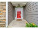 Close-up of the bright red front door with sidelights, complemented by stone and gray siding at 607 Little Shoals Ct, Canton, GA 30115