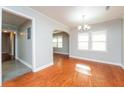 Cozy dining room with archway, hardwood floors, neutral walls, and chandelier at 10149 Puckett Sw St, Covington, GA 30014
