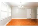 Bright living room features gleaming hardwood floors, a modern chandelier, and ample natural light at 10149 Puckett Sw St, Covington, GA 30014
