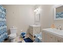 Bright bathroom featuring dual sinks with white cabinets and a shower with blue accents at 561 Holland Rd, Dallas, GA 30157