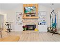 Cozy living room with a stone fireplace, built-in bookshelves, and wood-look flooring at 561 Holland Rd, Dallas, GA 30157