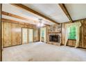 Cozy living room features a stone fireplace, wood paneling, and exposed beam ceiling at 2612 Spring St, Dacula, GA 30019