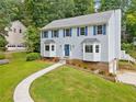 Well-maintained two-story home with blue shutters, a walkway, and landscaped front yard on a sunny day at 4197 Chadds Xing, Marietta, GA 30062