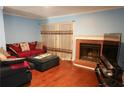 Cozy living room featuring a brick fireplace, hardwood floors, and large window at 852 Glynn Oaks Dr, Clarkston, GA 30021