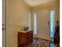 Bright entryway featuring hardwood floors, a white door, and a stylish dresser with marble top at 110 Baltusrol Way, Covington, GA 30014