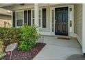 Inviting front entrance with black door, sidelights, shutters, and landscaped garden at 110 Baltusrol Way, Covington, GA 30014