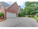 Spacious three car garage features a long driveway and mature greenery at 1721 Crowes Lake Ct, Lawrenceville, GA 30043