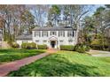 Lovely two-story home with shutters, a brick pathway, and a lush green lawn at 2955 Rhodenhaven Nw Dr, Atlanta, GA 30327