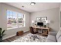 Bright home office featuring large window, modern desk, and comfortable seating area at 325 Nutwood Trce, Locust Grove, GA 30248