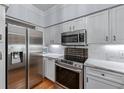 Modern kitchen featuring stainless steel appliances, white cabinets, and marble countertops at 3777 Peachtree Ne Rd # 1313, Brookhaven, GA 30319