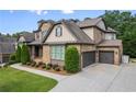 Stunning home featuring a two-car garage with ample driveway space and lush landscaping for added privacy at 8920 Ellesmere Dr, Cumming, GA 30041