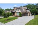 Beautiful home with a spacious driveway leading to a two-car garage and a basketball hoop for outdoor recreation at 8920 Ellesmere Dr, Cumming, GA 30041