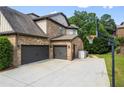 Spacious two car garage featuring ample driveway space, additional storage and an exterior basketball hoop at 8920 Ellesmere Dr, Cumming, GA 30041