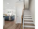 Modern interior design with an open layout, featuring hardwood floors, and a staircase with a wood and black banister at 4160 Cavalier Way, Duluth, GA 30097