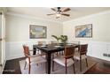 Elegant dining room featuring hardwood floors, wainscoting, contemporary art, and a ceiling fan at 4837 Mystere Sw Cir, Lilburn, GA 30047