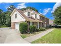 Side view of home features a brick facade, attached garage, and well-maintained landscaping at 4837 Mystere Sw Cir, Lilburn, GA 30047