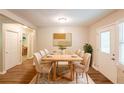 Bright dining room with a modern table set for eight, hardwood floors, a decorative rug, and a large window at 6662 Birchwood Ct, Winston, GA 30187