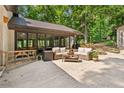 Covered patio with outdoor seating, enclosed sunroom, and backyard trees at 4025 Demooney Rd, Atlanta, GA 30349