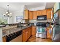 Well-lit kitchen featuring stainless steel appliances, granite countertops, and wood cabinets at 2465 Main St # 201, Atlanta, GA 30344