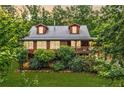 Charming two-story log cabin with a metal roof and beautifully landscaped front yard at 521 E East Valley Road Northeast Ne Rd, Rydal, GA 30171