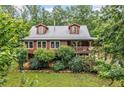 Charming two-story log cabin with a metal roof and beautifully landscaped front yard at 521 E East Valley Road Northeast Ne Rd, Rydal, GA 30171