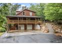 Exterior view showcasing the home's garage with two doors and a wooden upper-level deck at 521 E East Valley Road Northeast Ne Rd, Rydal, GA 30171