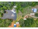 Expansive aerial view showcasing a property with a house, pond, shed, and RV shed, surrounded by lush greenery in Palmetto, GA at 6160 Campbellton Redwine Rd, Chattahoochee Hills, GA 30268