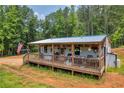 Charming exterior view with a porch, featuring a rustic design and a welcoming entrance at 6160 Campbellton Redwine Rd, Chattahoochee Hills, GA 30268