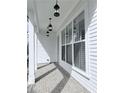 Inviting front porch with brick flooring, white columns, and modern hanging lantern lights at 992 Harvest Park Ln, Suwanee, GA 30024