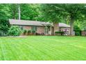 Beautifully landscaped brick home with a lush green lawn and mature trees in a serene setting at 2884 Bent Creek Nw Dr, Kennesaw, GA 30152