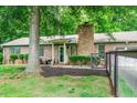 Brick home featuring a cozy front patio, manicured landscaping, and fenced yard at 2884 Bent Creek Nw Dr, Kennesaw, GA 30152